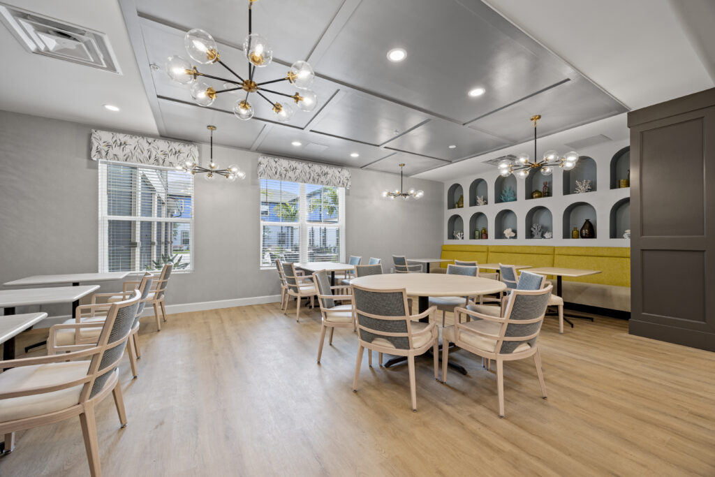 Bright dining space with contemporary decor, comfortable seating, large windows, and artistic shelving for ambiance.
