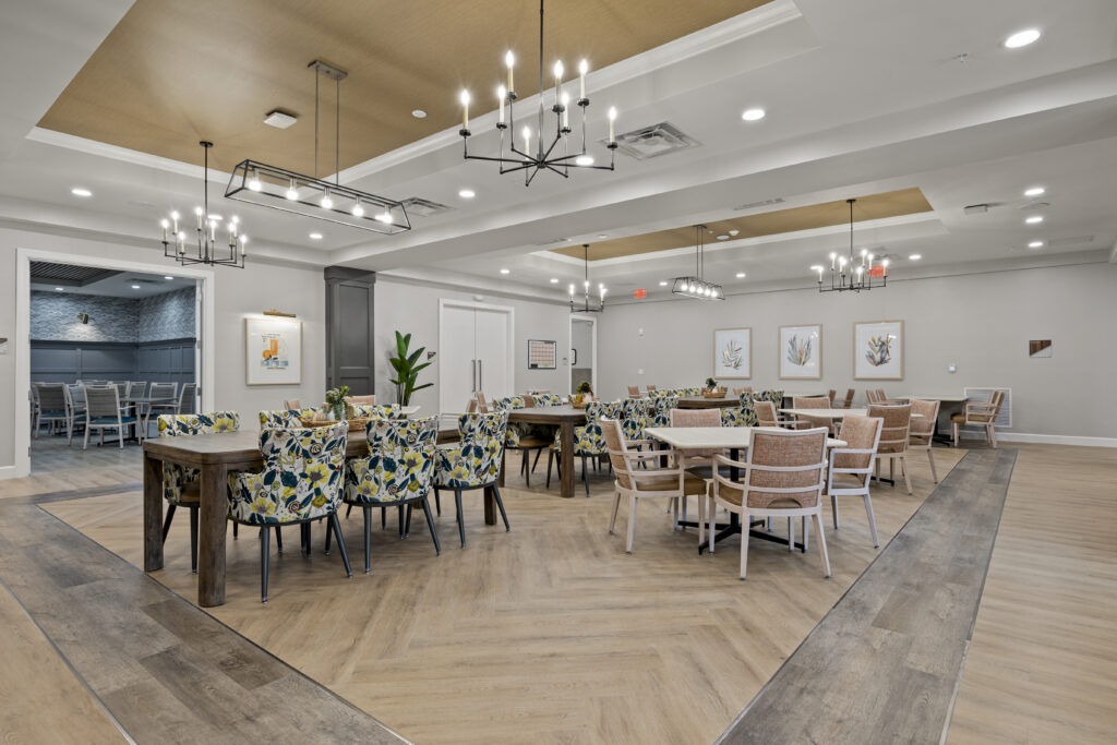 Spacious, stylish dining area with floral-patterned chairs, modern lighting fixtures, and inviting tables for group dining.