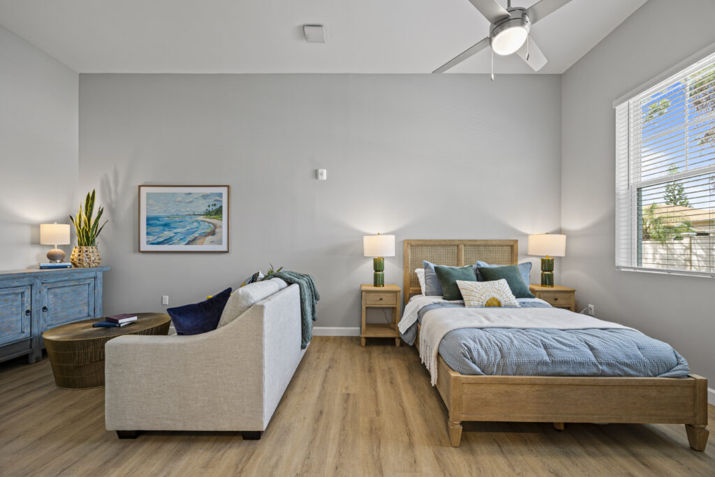 Studio apartment showcasing lounge seating next to a bed, complemented by contemporary décor.