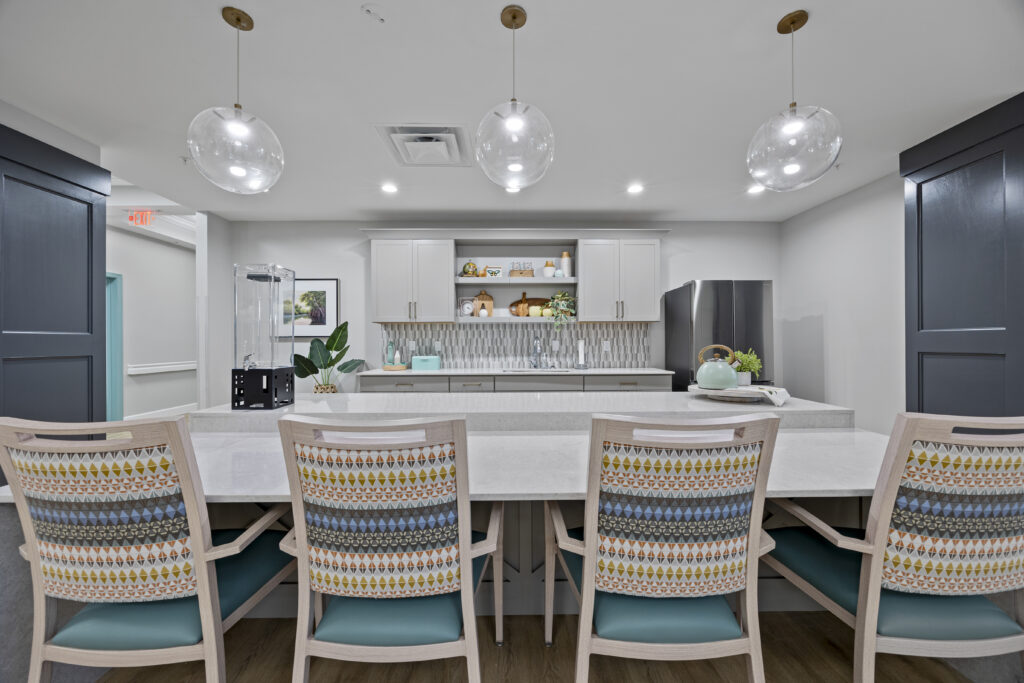 View of a modern kitchenette with stylish lighting, seating, and contemporary decor.