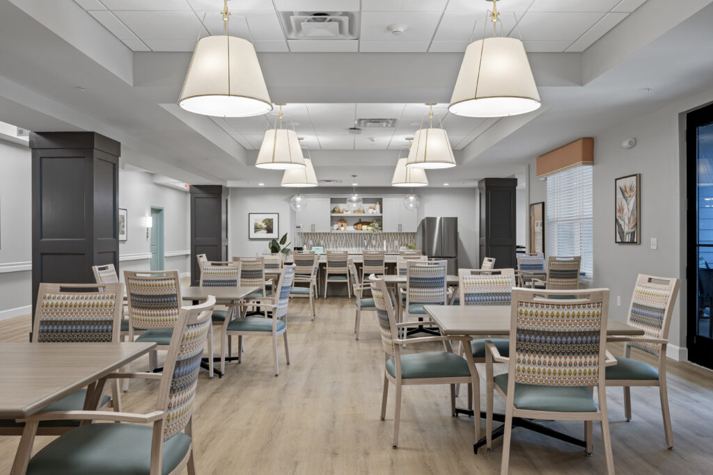 Spacious dining area connected to the kitchenette, featuring tables, chairs, pendant lights, and elegant interior design.