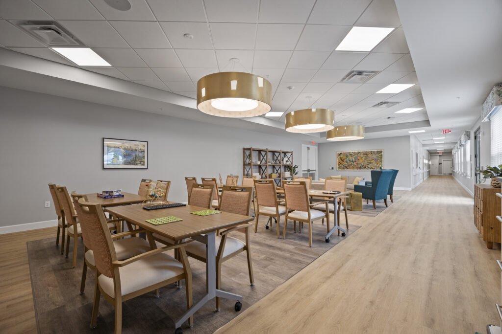 Dining room perspective facing outward toward large glass doors, with cozy seating in the foreground.