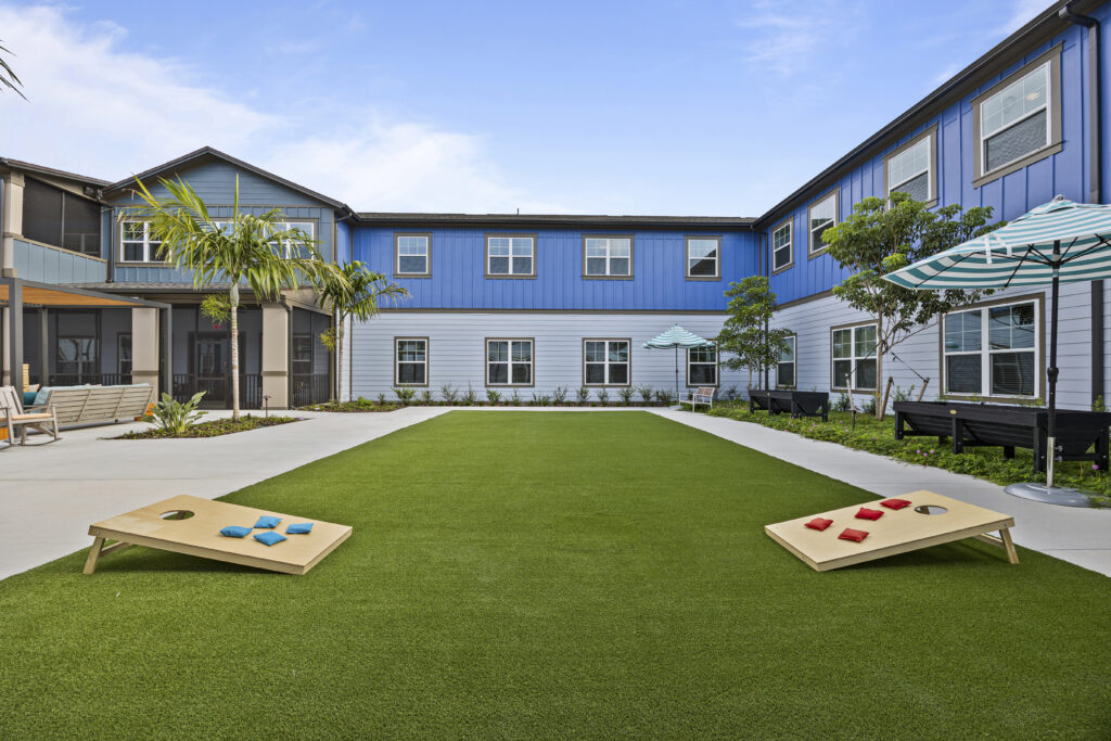 Outdoor courtyard featuring activities such as Cornhole